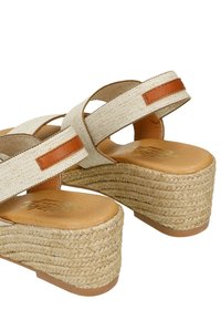 Wedge sandals with a textured beige fabric upper, brown leather accents, and a rope-wrapped platform sole. Smooth tan insole visible.