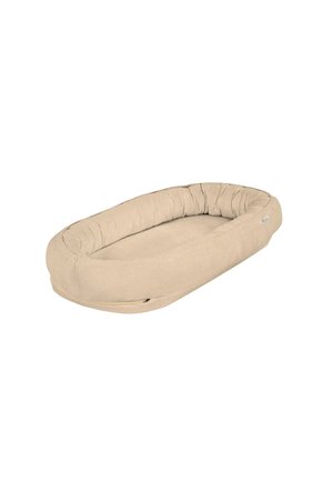 Oval beige cushioned pet bed with raised, padded sides and a soft textured fabric cover.