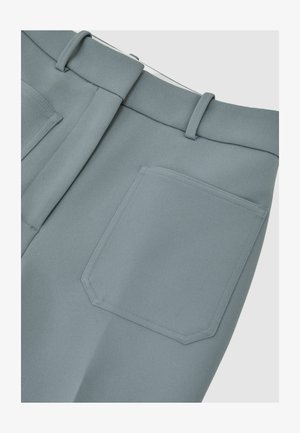 Lyseblå skræddersyede bukser med en struktureret tekstur, der har fladt frontstykke, bæltestropper og en enkelt påsyet lomme bagpå.