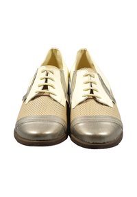 Scarpe in pelle perforata beige e crema con accenti metallici oro, punta tonda, sei occhielli e dettagli ricamati sui lati.