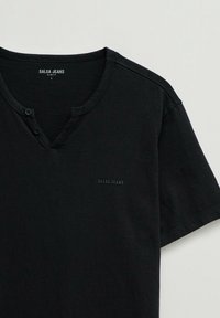 Chemise noire slim fit à manches courtes, avec un col en V et deux boutons, brandée "Salsa Jeans" sur la poitrine et à l'intérieur du col.