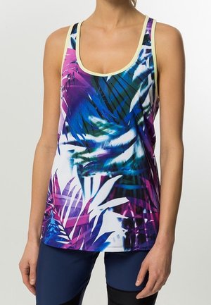 Débardeur sans manches avec encolure dégagée présentant un motif tropical de feuilles vibrant en violet, bleu et blanc, porté avec des leggings bleu foncé.