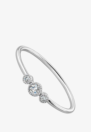 Anillo de tono plateado con una banda fina y lisa que presenta tres piedras circulares de corte brillante y claro, engastadas en halos decorativos.