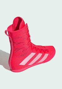Scarpa da ginnastica rosa con design alto, realizzata in materiale testurizzato. Presenta tre strisce bianche, tomaia testurizzata e allacciatura frontale.