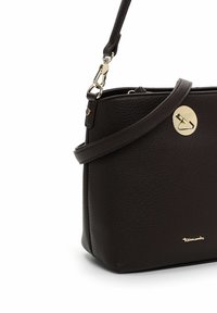 Černá texturovaná kožená kabelka přes rameno se zlatým kruhovým zapínáním a nastavitelným popruhem, zdobená malým zlatým logem značky.