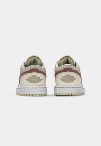 Scarpe da ginnastica Air Jordan con design beige e marrone scuro, materiale in pelle, collo imbottito e suola esterna testurizzata con dettaglio del logo sul tallone.