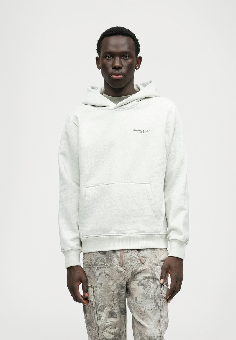 Hellgrau Kapuzenpullover mit Kängurutasche und gerippten Bündchen. Verfügt über ein kleines schwarzes Logo auf der Brust und einen weichen, strukturierten Stoff.