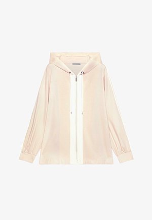 Jasno beżowa kurtka z kapturem na zamek błyskawiczny, z długimi rękawami i białą lamówką przy zamku, wyposażona w sznurki przy kapturze i ściągacze na nadgarstkach.