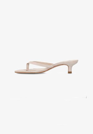 Sandale beige en daim à lanière avec un petit talon kitten bas et un bout carré, présentant un design minimaliste et une fine bride traversant le pied.