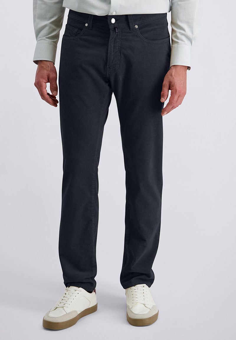 Dark gray jeans made of soft cotton with a classic fit, five-pocket design, button closure, and contrasting stitching. Paired with white sneakers.