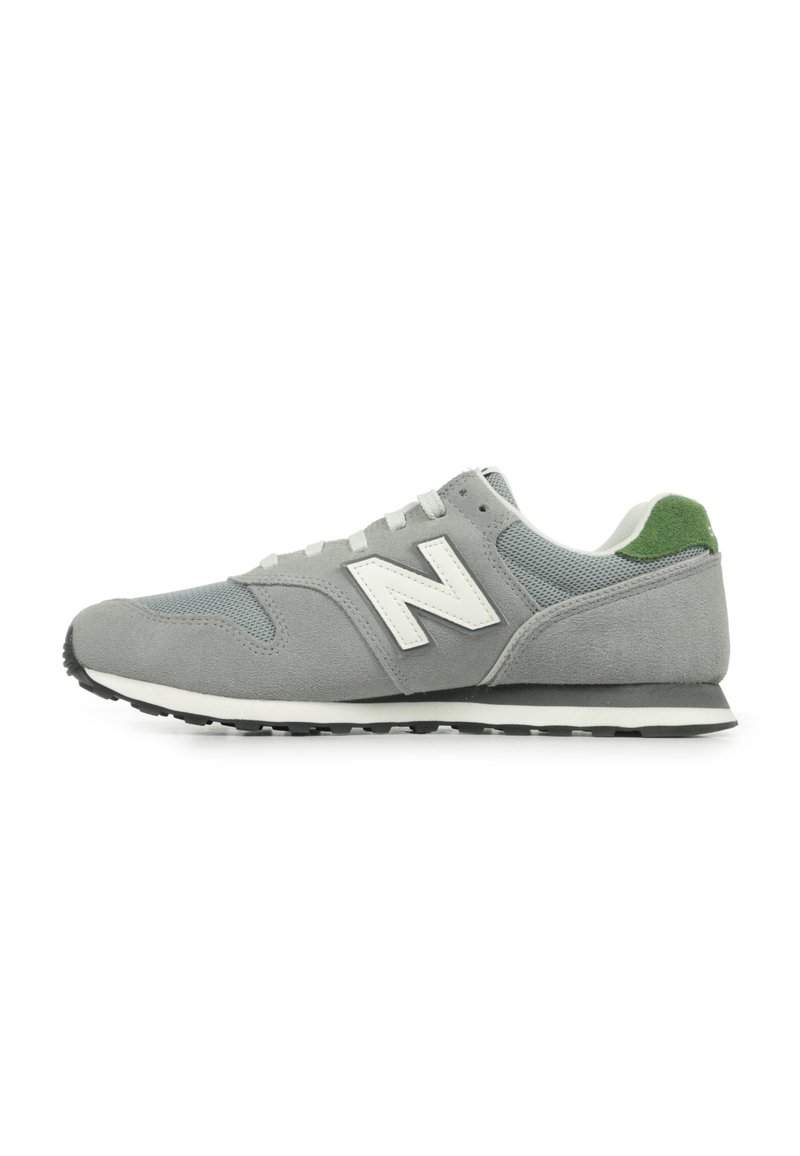 Sneaker grigia con tomaia in suede e mesh, dettagli bianchi, linguetta verde sul tallone e suola in gomma nera. Presenta un classico design con lacci.