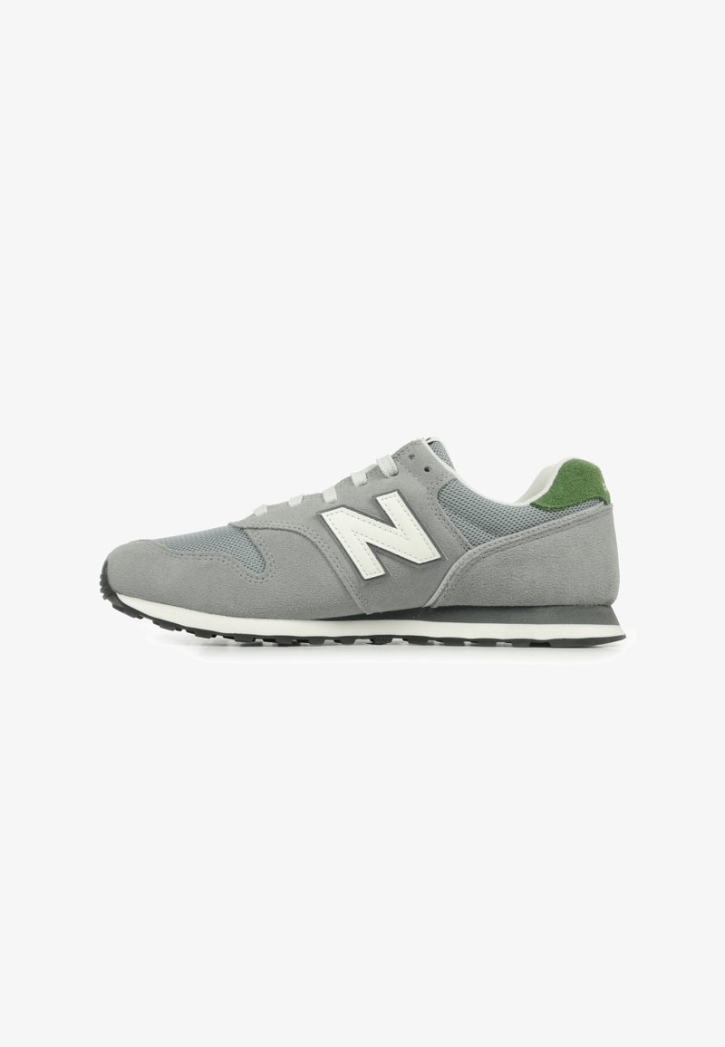 Sneaker grigia con tomaia in suede e mesh, dettagli bianchi, linguetta verde sul tallone e suola in gomma nera. Presenta un classico design con lacci.