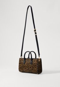 Leather handbag with leopard print, featuring a structured shape, two black handles, an adjustable strap, and gold-tone hardware accents.