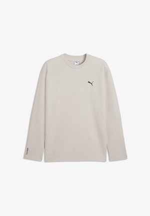Beige langærmet Puma-shirt med rund halsudskæring og sort Puma-logo på venstre bryst samt lille tekst på venstre ærmekant.