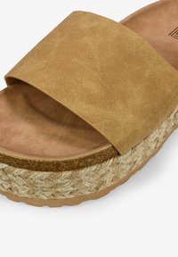 Sandale à glissière en faux cuir tan avec une large sangle, semelle en jute tissé et semelle intérieure rembourrée marron clair. Détail de surface texturé.