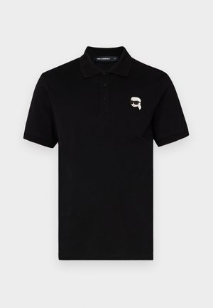 Zwarte polo in katoen met een kraag, drie knopen en een klein wit logo op de linkerborst. Korte mouwen en rechte snit.