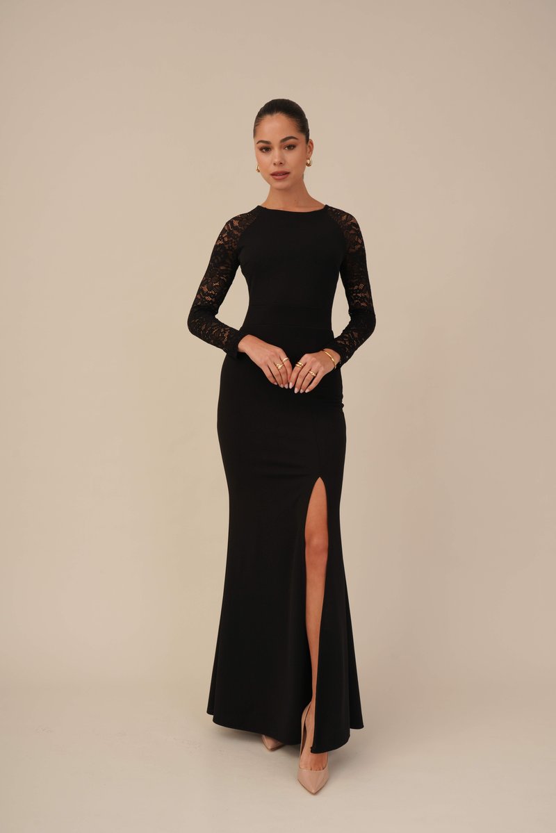 Black long-sleeve dress with lace detailing, fitted bodice, and a thigh-high slit. Smooth fabric finishes in a flared silhouette.
