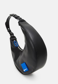 Mustalla nahkaselkärepulla, jossa on kaareva muoto, sinisellä vetoketjun vedin ja sininen korostusneliö. Sileä pinta ja säädettävä olkahihna.