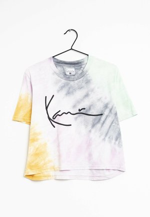 Koszulka z krótkim rękawem z efektem tie-dye w żółtych, szarych i pastelowych odcieniach, czarny tekst w stylu podpisu z przodu, wisząca na czarnym wieszaku na białym tle.