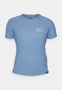 Světlomodré tričko s krátkým rukávem vyrobené z měkkého materiálu. Má kulatý výstřih a malý grafický motiv s textem a horskou krajinou.