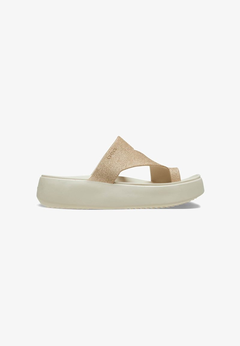 Goldene Glitzer-Flip-Flop-Sandale mit einem breiten Riemen über dem Fuß, erhöhtem weißen Plateau und strukturiertem Profil für besseren Halt.