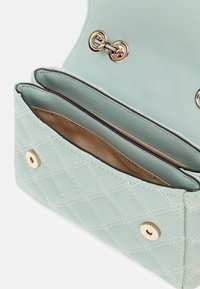 Borsa a mano in pelle verde menta con design trapuntato, dotata di due scomparti interni e dettagli in metallo dorato. Texture morbida e finitura liscia.