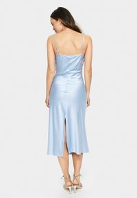 Ljusblå satin klänning med spagettiband, figursydd bodice och en slits bak, som faller nedanför knäet. Slät yta och rena linjer.