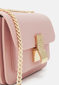 Różowa skórzana torebka na ramię z złotym łańcuszkiem, prostokątnego kształtu, z magnetycznym zapięciem klapy i złotym akcentem na frontowej części.