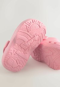 Roosad kummist jalanõud tekstuuriga tallaga, millel on loomade ja kujundite mustrid. Disainis on ümmargused detailid ja ventilatsiooniavad.