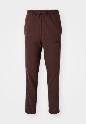 Bordeaux joggers met een trekkoord in de taille, zwarte zijpanelen en een Adidas-logo op de linker dij. Gladde stofstructuur, taps toelopende pasvorm.