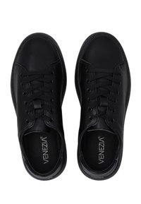 Pár černých kožených šněrovacích polobotek s kulatými špičkami a viditelným logem "Venezia" uvnitř.