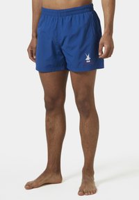 Bañadores azules con cintura elástica. Presentan un pequeño logo blanco y detalles rojos en el lateral. Fabricados en tela ligera y con un corte por encima de la rodilla.