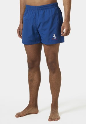 Bañadores azules con cintura elástica. Presentan un pequeño logo blanco y detalles rojos en el lateral. Fabricados en tela ligera y con un corte por encima de la rodilla.