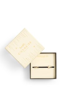 Mustat Coach-kynät kultaisilla yksityiskohdilla, esitelty beigeessä laatikossa, jossa on tähden kuvio ja kohokuvioitu logo. Laatikon sisäosa on kermaisen värinen.