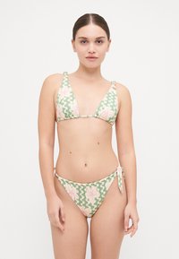 Bikini-set med ett grönt och rosa blommönster, med triangulärt överdel och justerbart sidband på botten. Tillverkad av mjukt tyg.