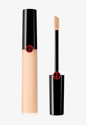 Liquid foundation in a cylindrical frosted glass bottle with a black cap, featuring a red logo. Includes a sponge applicator wand.
