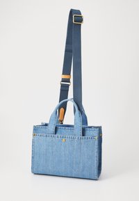 Denim bevásárlótáska két füllel és levehető, állítható pánttal. Világoskék szín, aranyszínű fémrészek, és varrott díszítések.