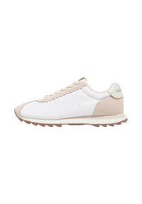 Trampki z białą tkaniną w górnej części i beżowymi akcentami z zamszu, z falistym wzorem wzdłuż strefy sznurowania, gumową podeszwą i minimalnym brandingiem.