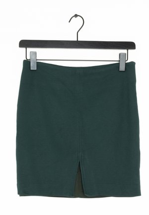 Donkergroene, nauwsluitende rok met een lengte tot halverwege de dij en een split aan de achterkant. Gemaakt van gestructureerde stof, hangt aan een zwarte clip en haak.