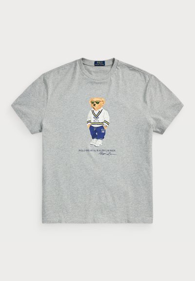 Grå bomullströja med en grafik av en björn i en vit och blå outfit. "Polo Bear by Ralph Lauren" tryckt nedanför designen.