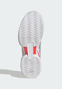 Shoe sole in white rubber with zigzag tread pattern. Features red accents and a gray section, branded with "adidas" and "Stella McCartney."