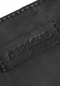 Črn usnjen denarnica z teksturirano površino in vtisnjenim logotipom "DEPECHE" ter kontrastnim šivom ob robu.