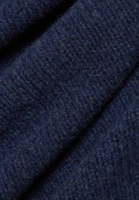 Granatowa dzianina o miękkiej, teksturowanej powierzchni, wykonana z mieszanki grubych i cienkich włókien w ogólnym prążkowanym wzorze.