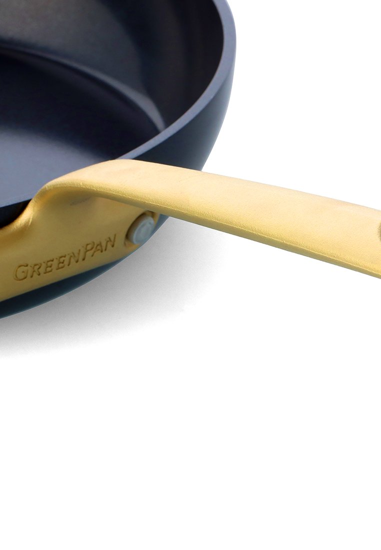 Anti-aanbak koekenpan met een donkerblauwe keramische binnenkant, gouden handvat en een duidelijk logo van de fabrikant gegraveerd op het oppervlak van het handvat.