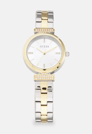 Montre en acier inoxydable argent et or avec un cadran blanc rond et des accents en cristal sur la lunette et le bracelet. Présente une finition lisse et un design maillon.