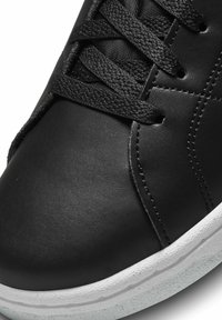 Sapatilha de couro preto com atacadores lisos pretos, bico arredondado, sola de borracha branca com detalhe texturizado e sutis acentos de costura.