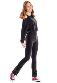 Black long-sleeve top with shoulder cutouts, paired with black fitted leggings and red high-top sneakers. Smooth texture, athletic fit.