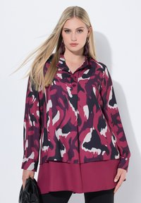 Blusa a maniche lunghe in una stampa astratta viola e nera, con colletto, bottoni e pannello inferiore a strati. Tessuto dalla texture liscia.