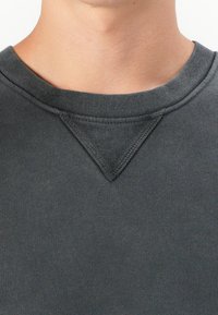 Sudadera de cuello redondo en carbón con un detalle texturizado en V en el cuello, hecha de un tejido suave y elástico con un acabado liso.