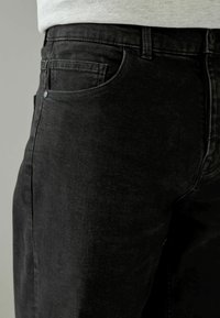 Zwarte spijkerbroeken van denim met een slim fit, voorzak, subtiele versleten textuur en metalen knoop bij de taille.